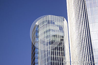 Blue corporate building with a frontal blue glass window wall. Stock Photo